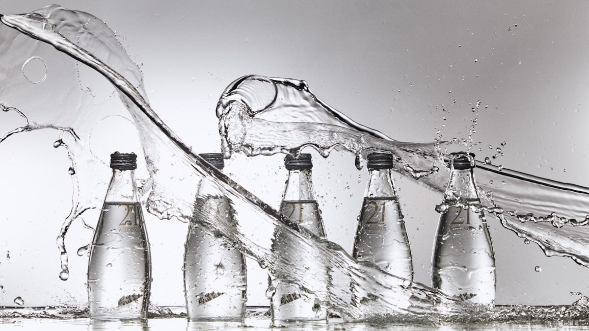 A group of bottles of water being filled with water